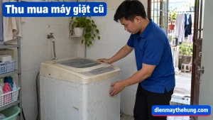 Nhân viên áo xanh xem máy giặt cũ tại nhà