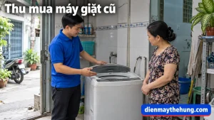Nhân viên áo xanh xem máy giặt cũ tại nhà