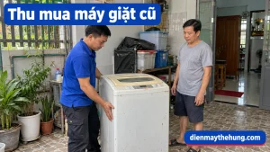 Nhân viên áo xanh xem máy giặt cũ tại nhà