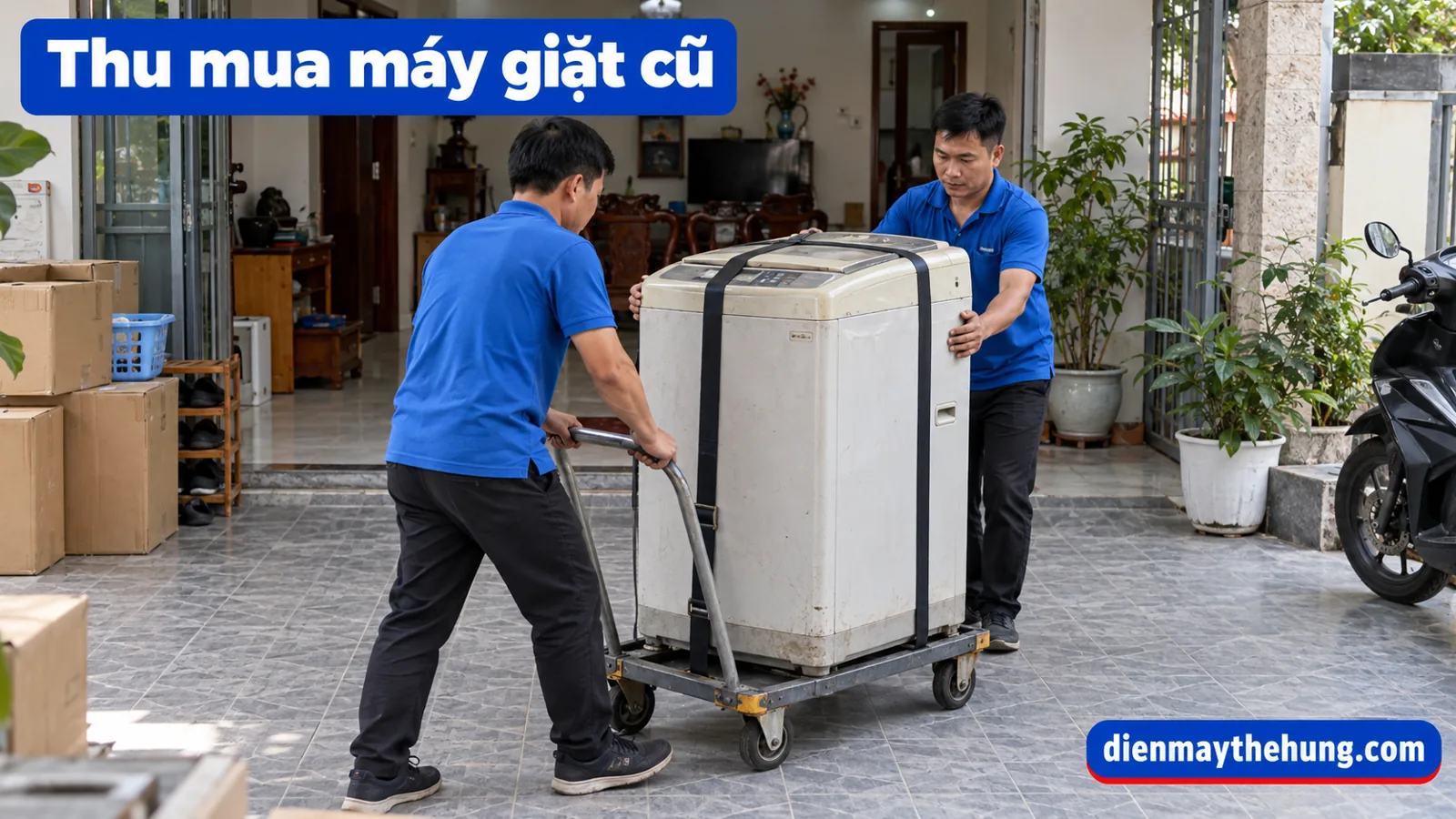 Hai người vận chuyển máy giặt bằng xe đẩy có dây giữ